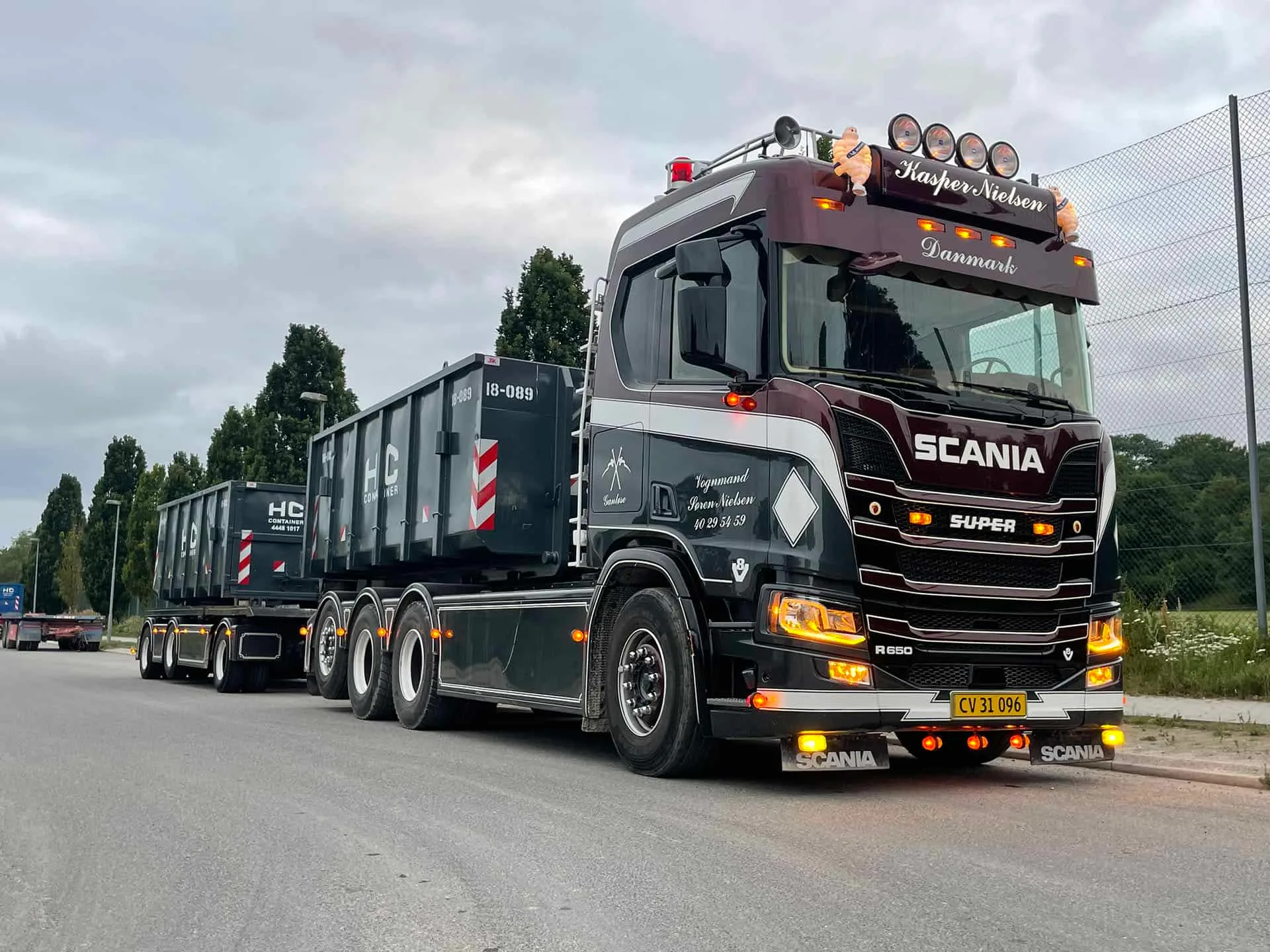 Scania-lastbil fra VSN Gruppen med to affaldscontainere på lad og trailer
