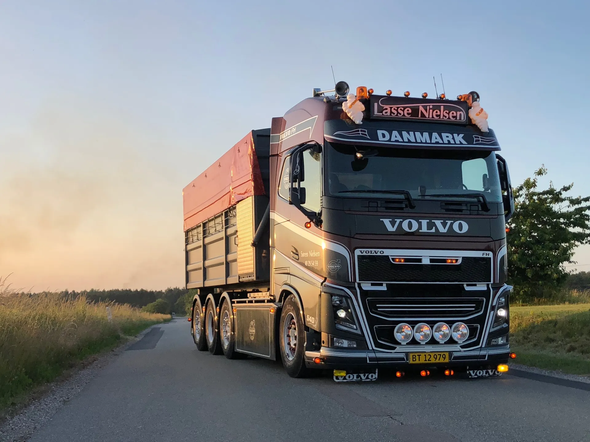 Volvo-lastbil fra VSN Gruppen på landevej i aftensol