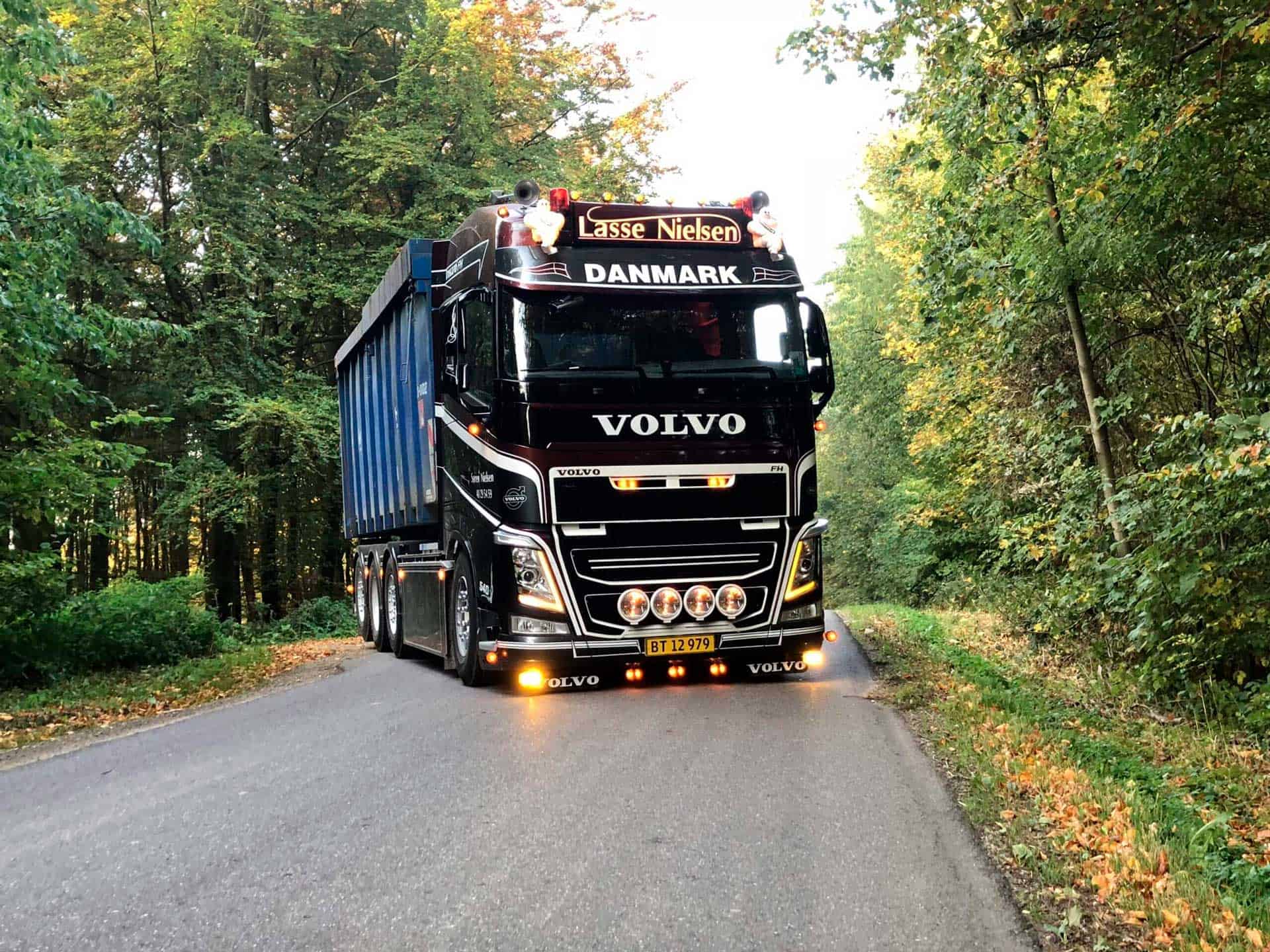 Volvo-lastbil fra VSN Gruppen på skovvej med container i efterårsfarver