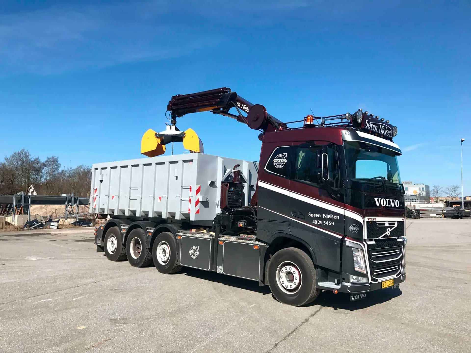 Volvo-kranbil fra VSN Gruppen løfter container med grab