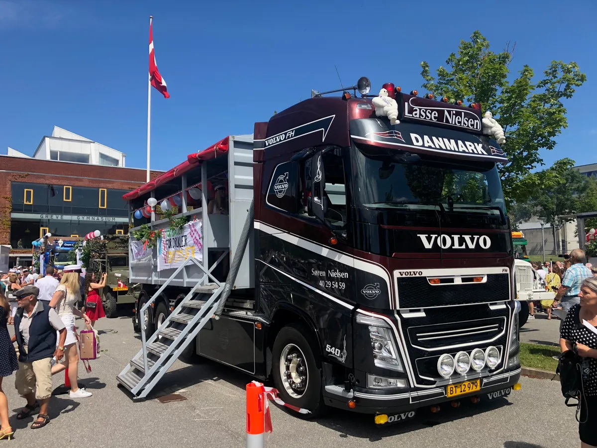 Pyntet Volvo-studentervogn fra VSN Gruppen på torv med Dannebrog og publikum