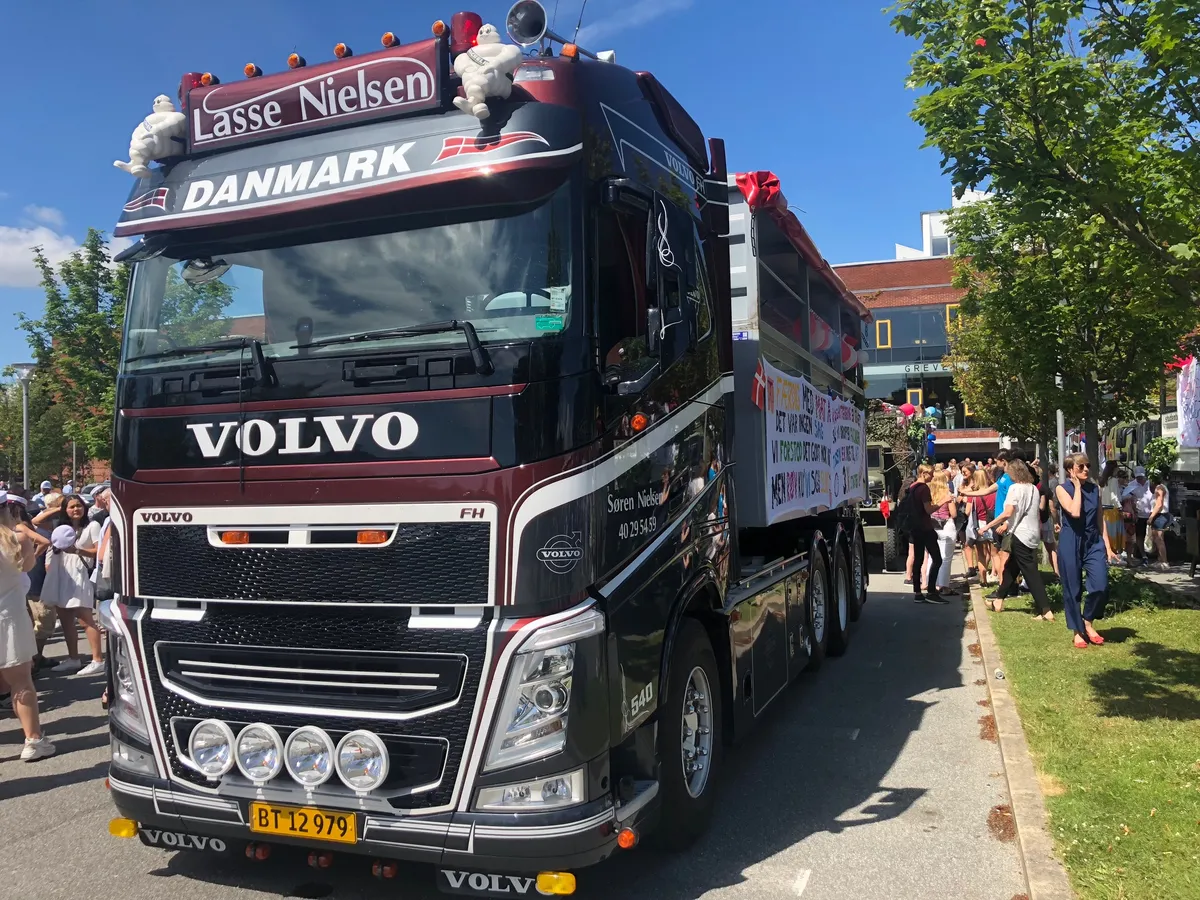 Pyntet Volvo-studenterlastbil fra VSN Gruppen i solskin på byens gade