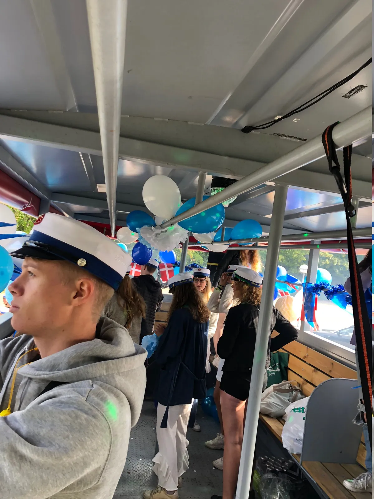 Studenter med huer ombord på pyntet studentervogn fra VSN Gruppen