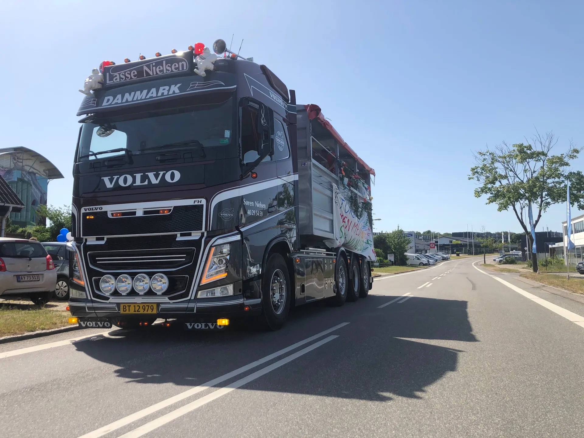Pyntet Volvo-studentervogn fra VSN Gruppen med balloner i blå sommerhimmel