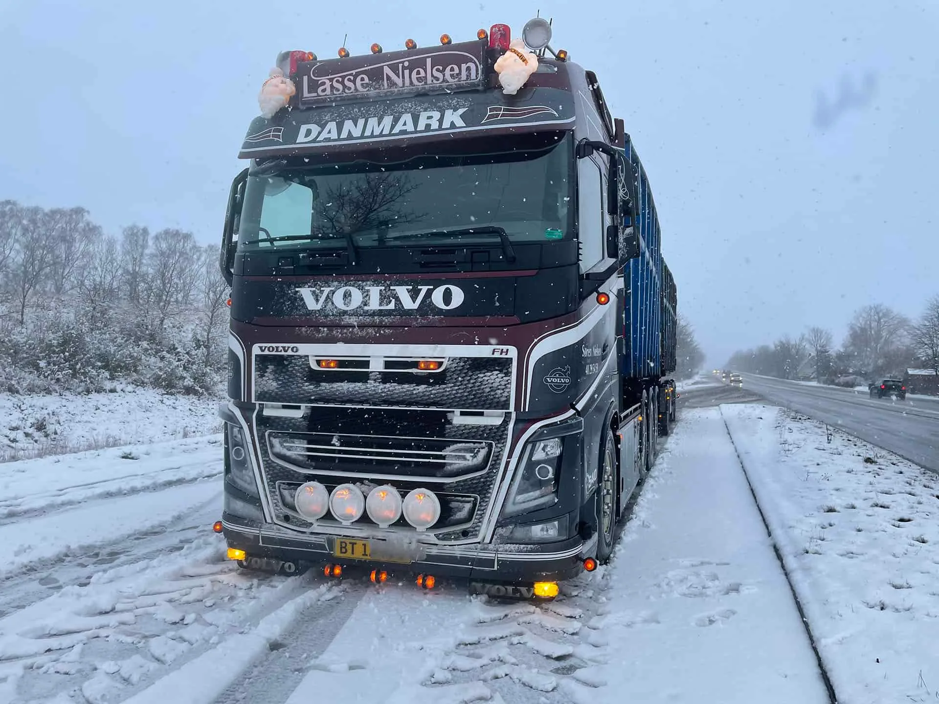 Volvo-lastbil fra VSN Gruppen på snedækket motorvej i snevejr