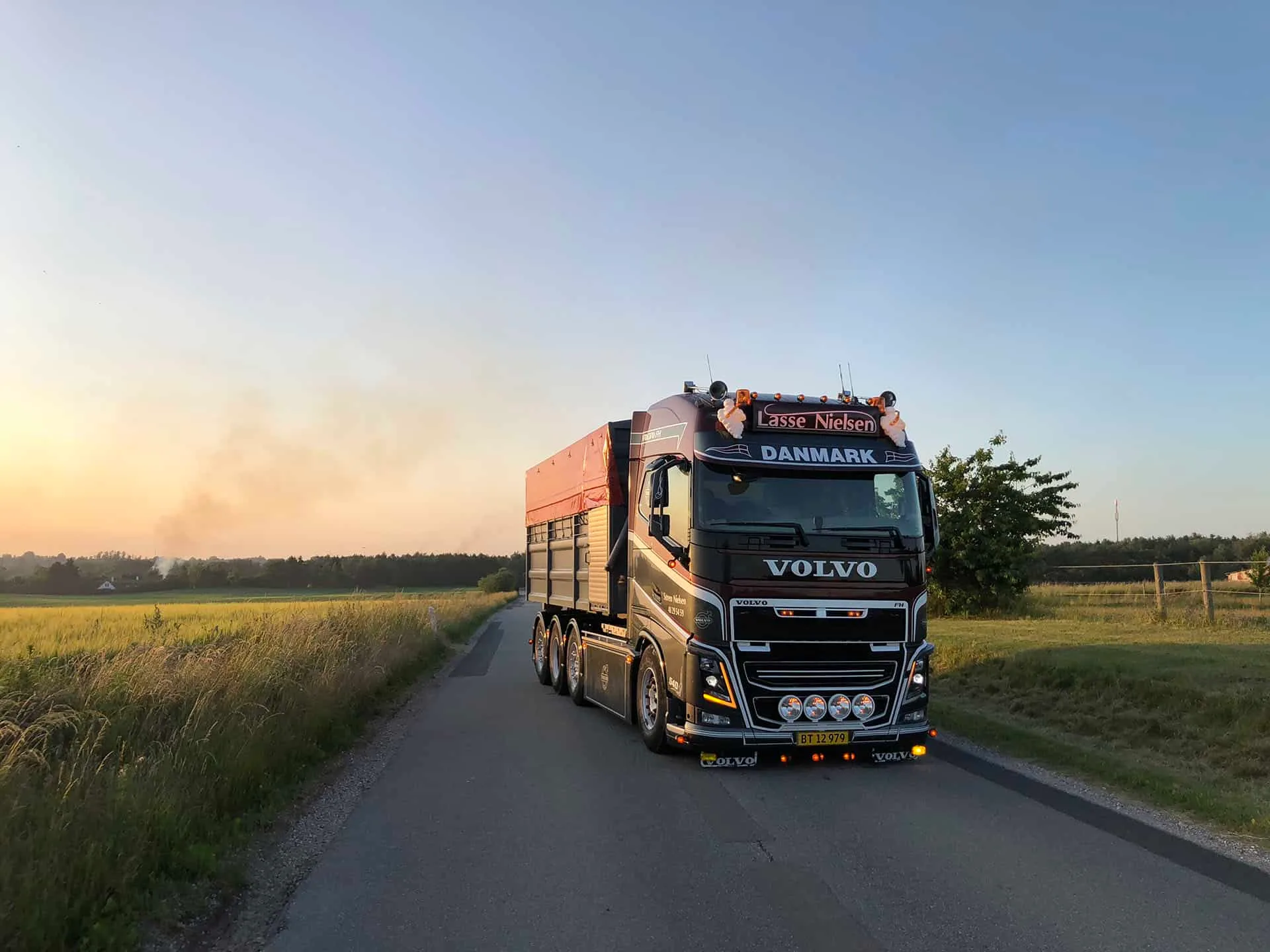 Volvo-lastbil fra VSN Gruppen kører på landevej i aftensol